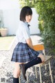 A woman in a school uniform sitting on a chair.