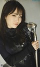 A woman holding a shower head in a bathroom.